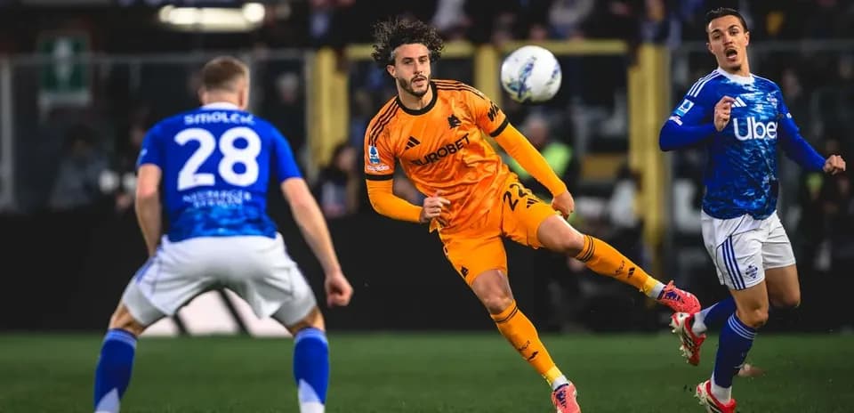 Player in orange jersey kicking the ball