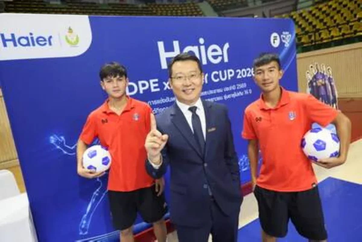 Two young football players with a representative at event
