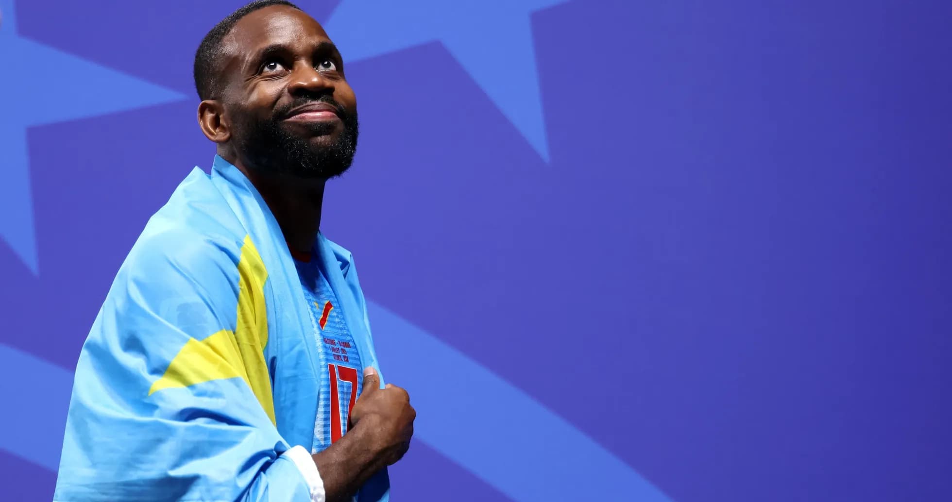 Athlete draped in flag during ceremony backdrop