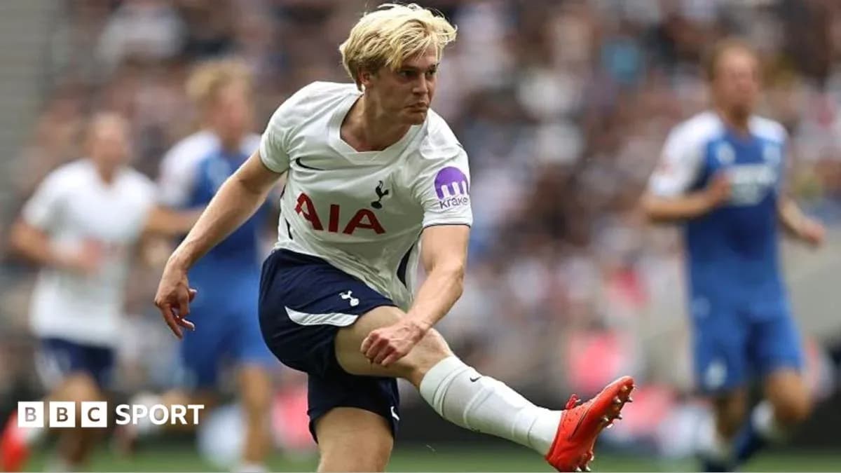 Tottenham player kicking ball during match action