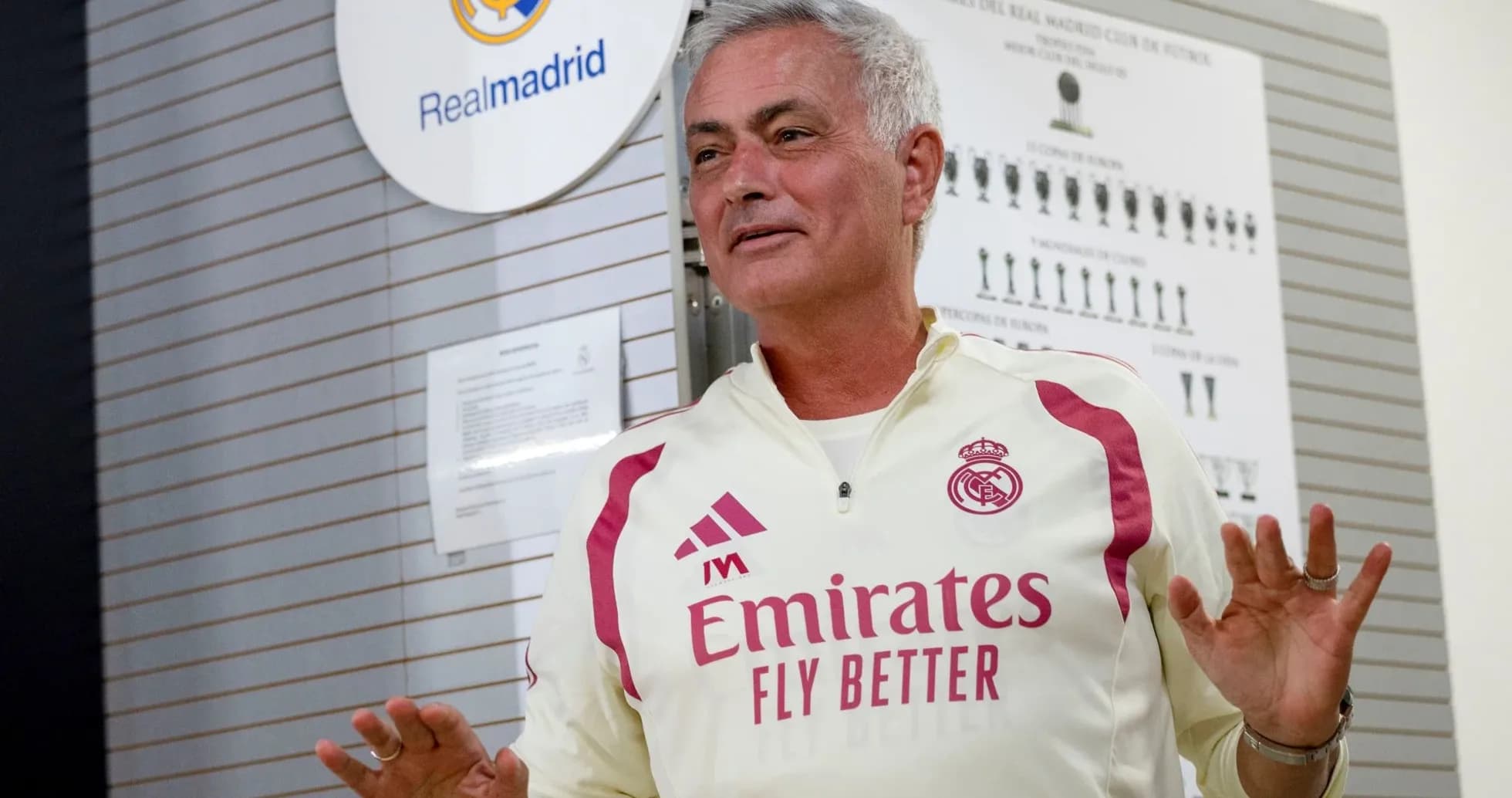 Coach speaking in front of Real Madrid logo