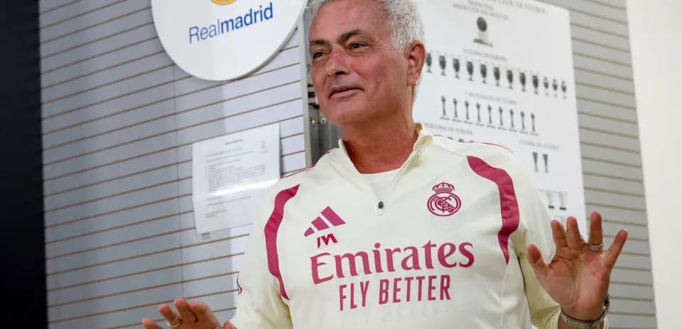 Coach speaking in front of Real Madrid logo
