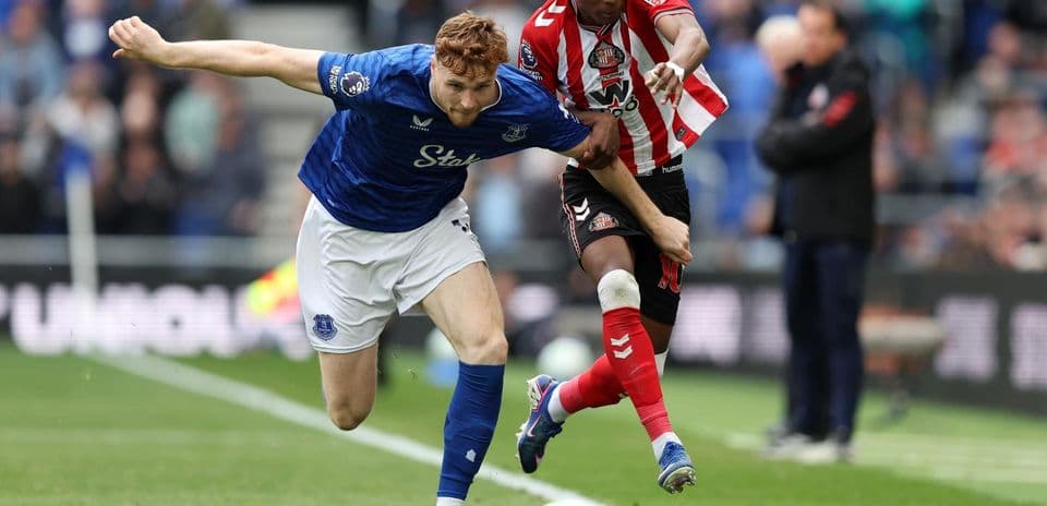 Everton player challenges Sunderland opponent for the ball