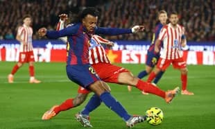 Barcelona player tackling Atletico Madrid opponent