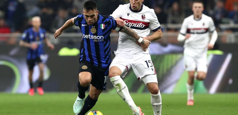 Bologna player challenging Inter player for the ball