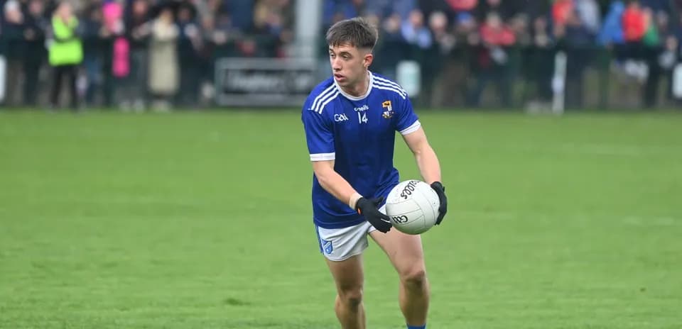 Player in blue jersey holding a football on field