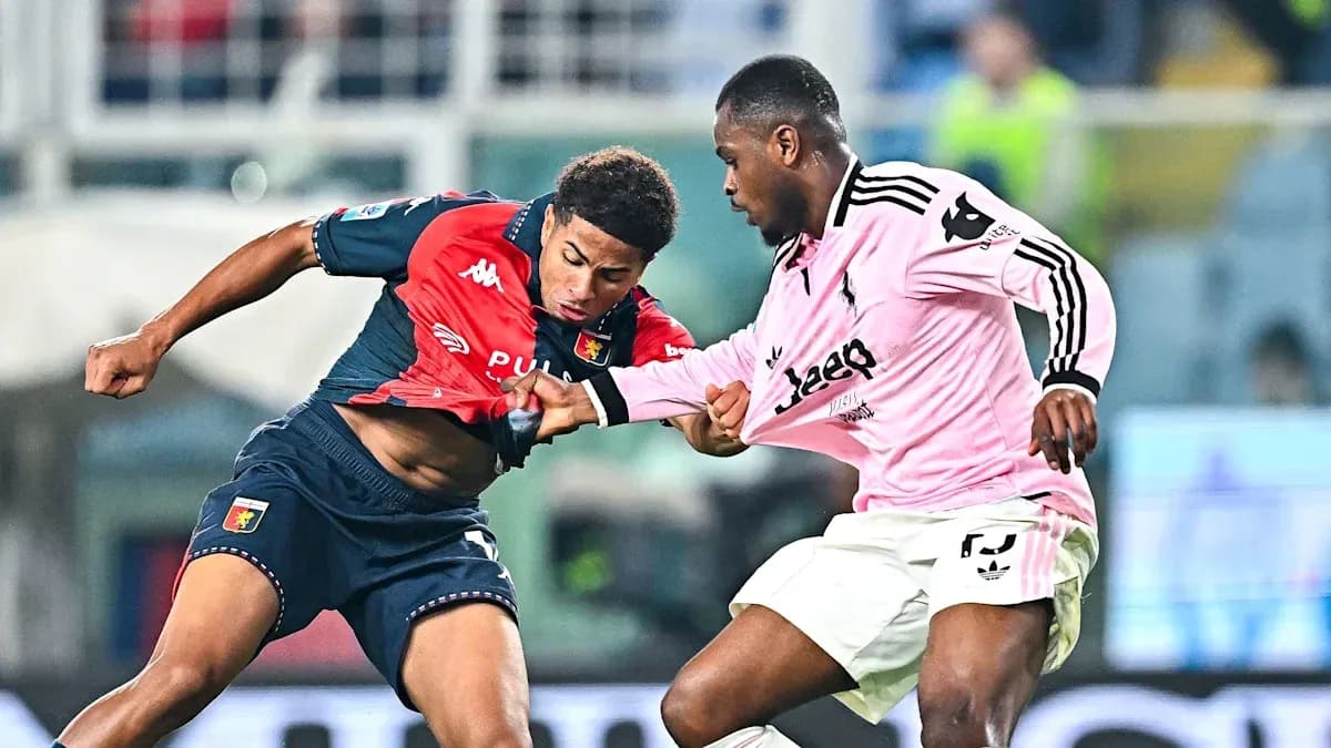 Genoa player challenges Juventus opponent for the ball