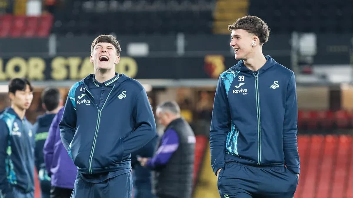 Two Swansea City players laughing during warm-up