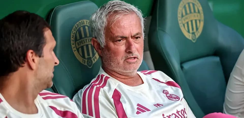Two coaches seated on team bench during match
