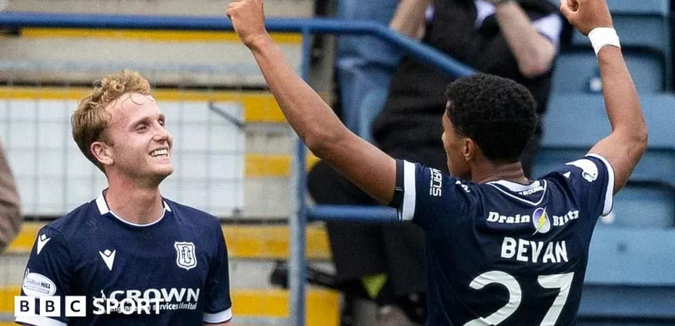 Two football players celebrating a goal together
