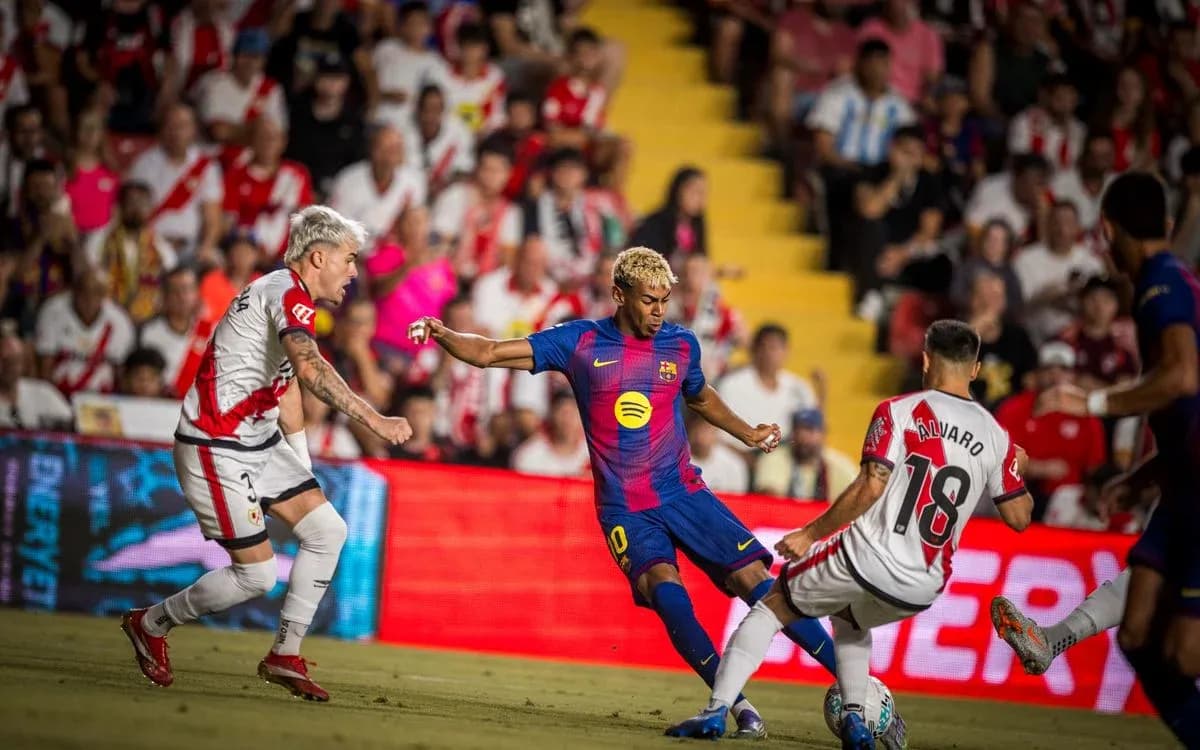 Barcelona player dribbling past Rayo Vallecano defenders