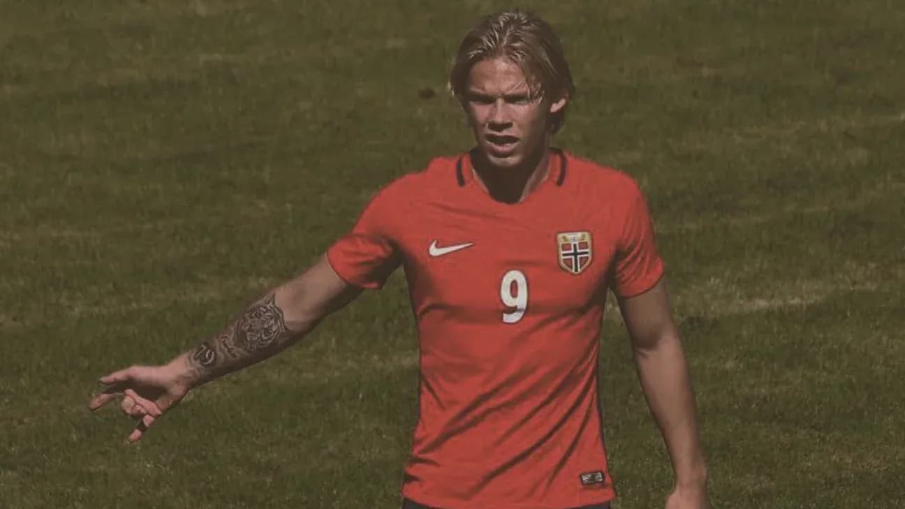 Player gesturing on the field in red jersey