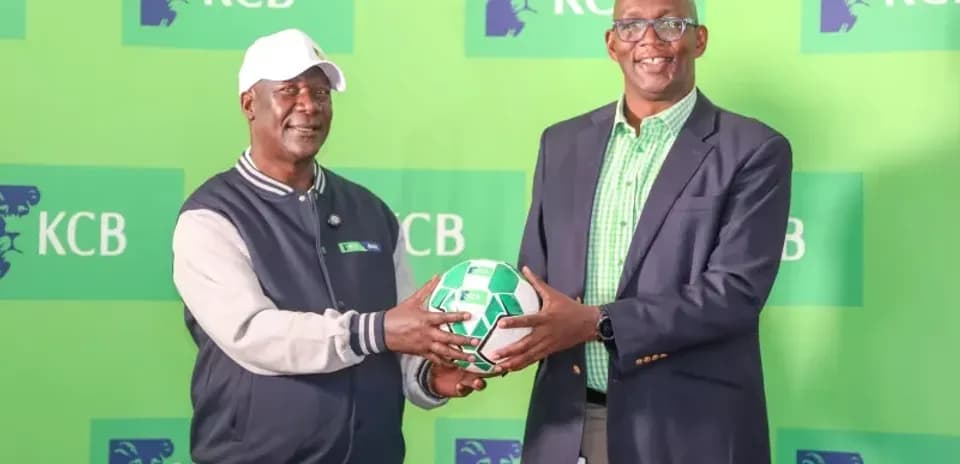 Two men holding a football at KCB event