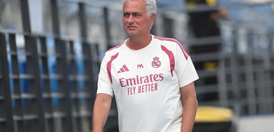 Coach walking on training pitch in team attire