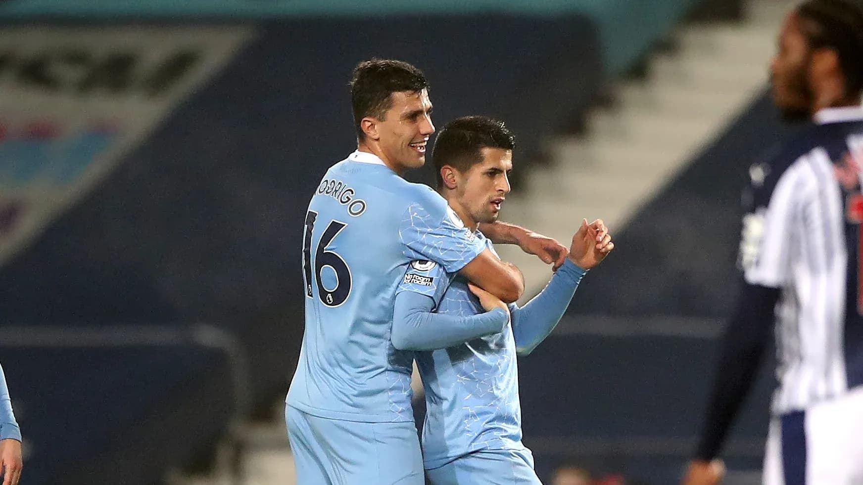 Two players celebrating a goal in blue jerseys