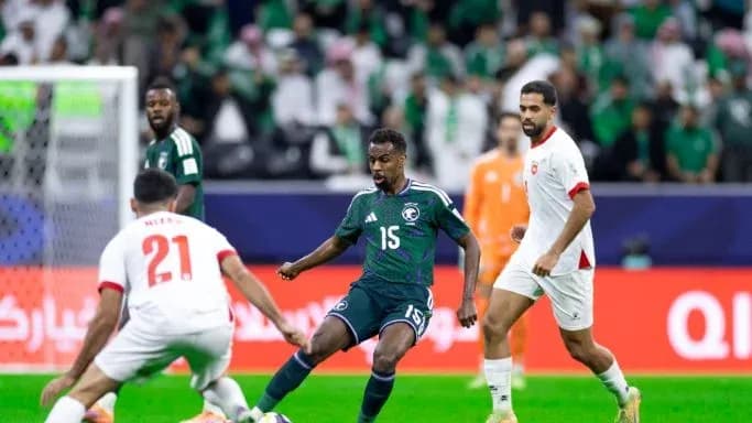 Saudi player dribbling past opponents during match