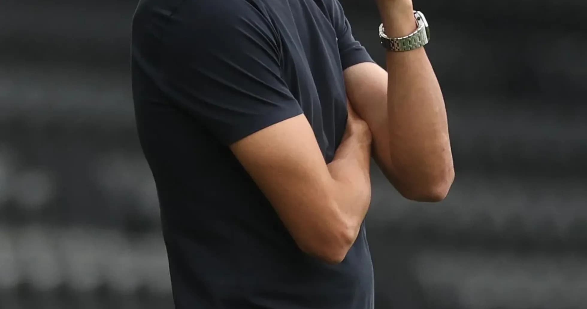 Coach observing the match with arms crossed