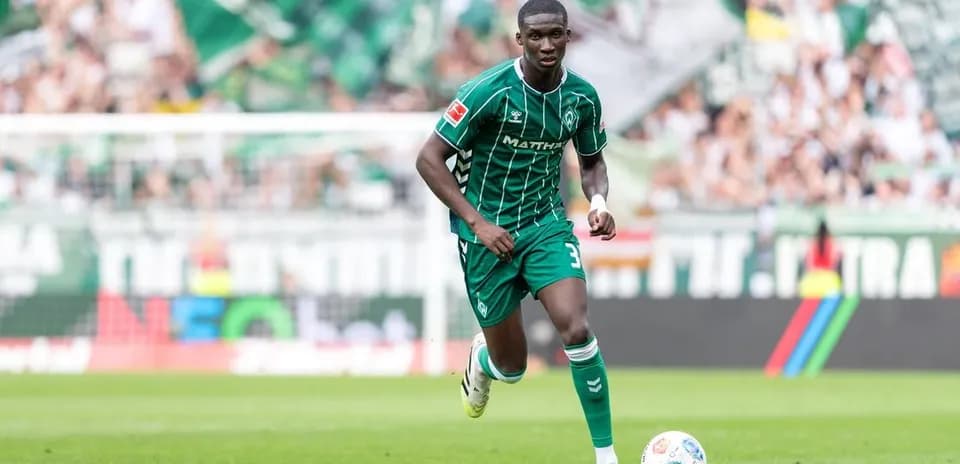Player in green kit running on the field