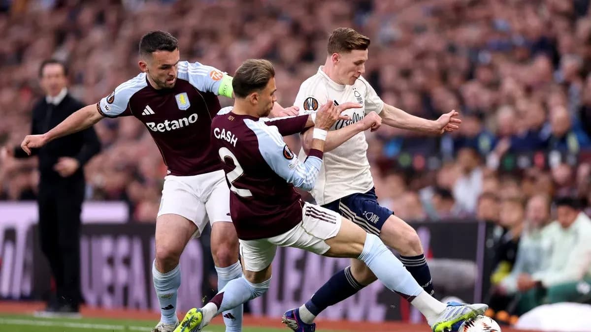 Two Aston Villa players tackling an opponent during match