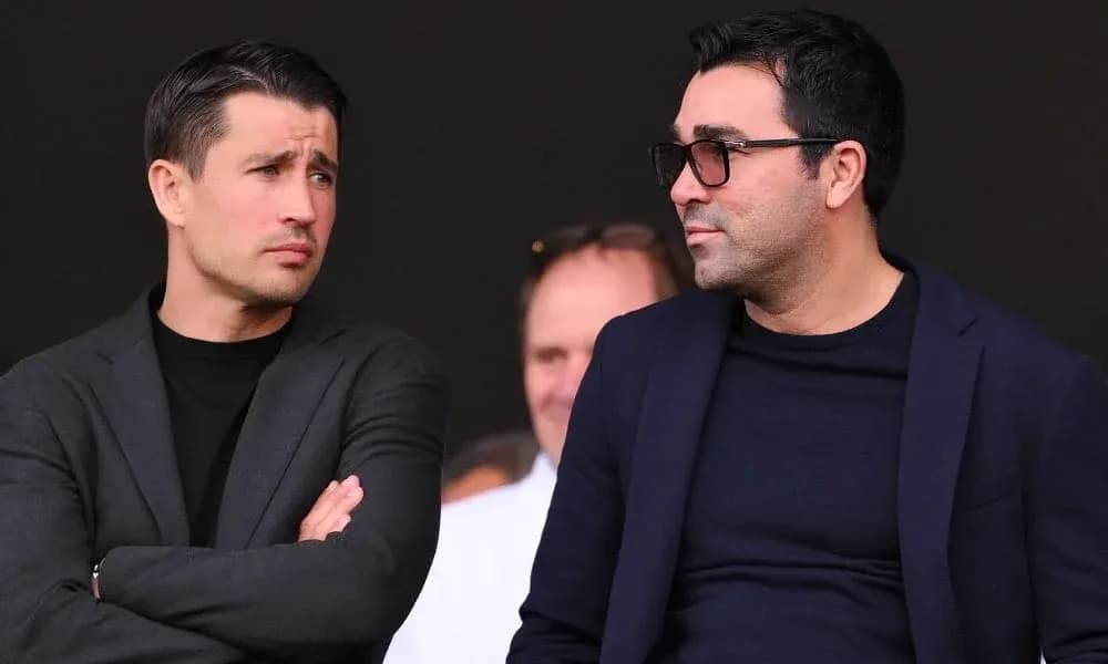 Two men conversing in a sports venue setting