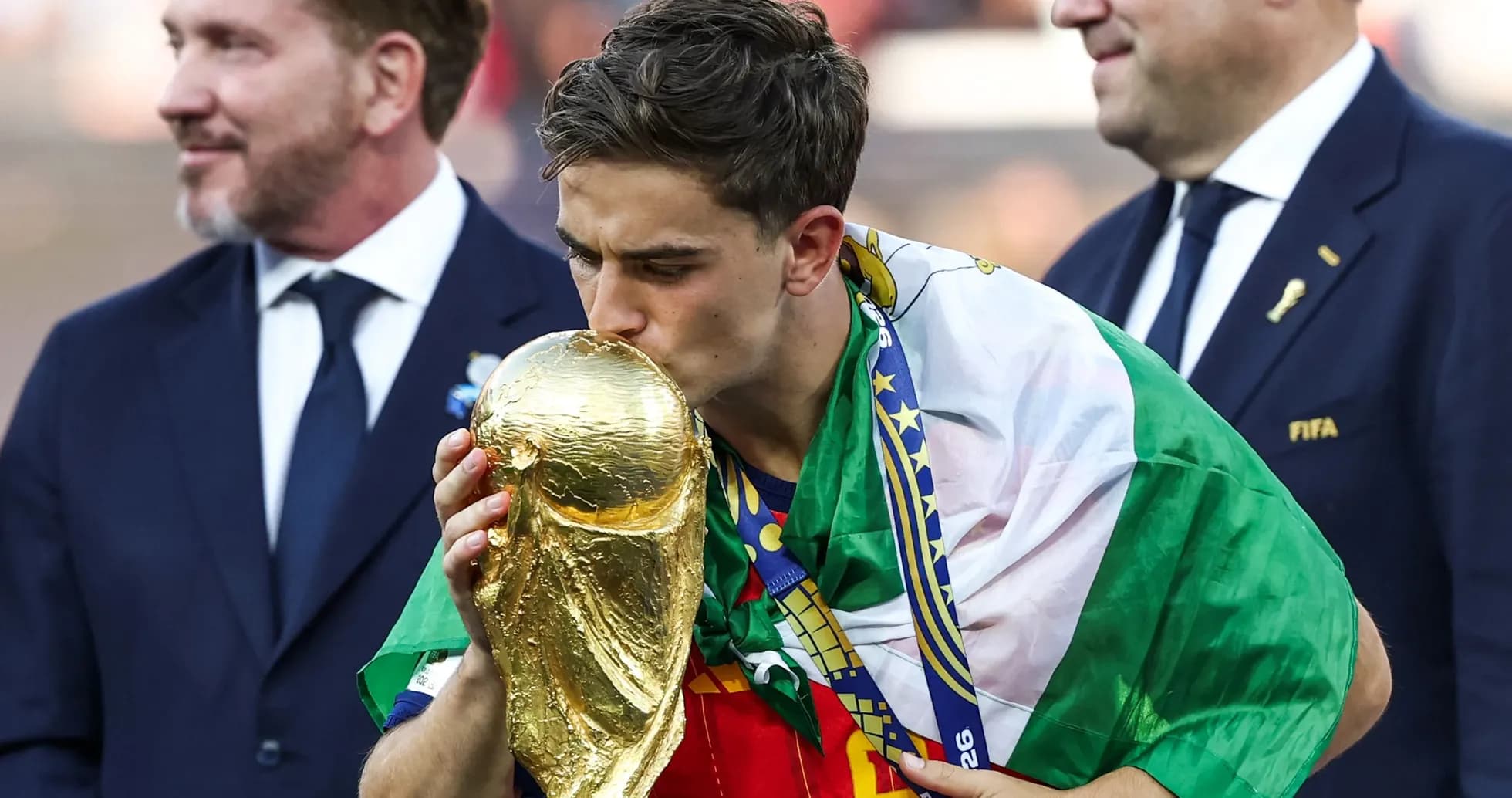 Player kissing FIFA World Cup trophy on podium