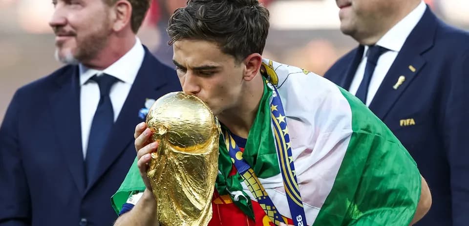 Player kissing FIFA World Cup trophy on podium