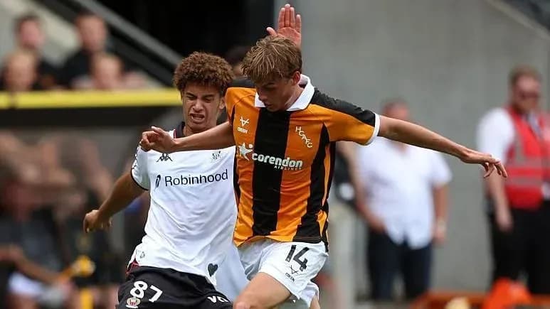 Player in black and orange shirt being challenged
