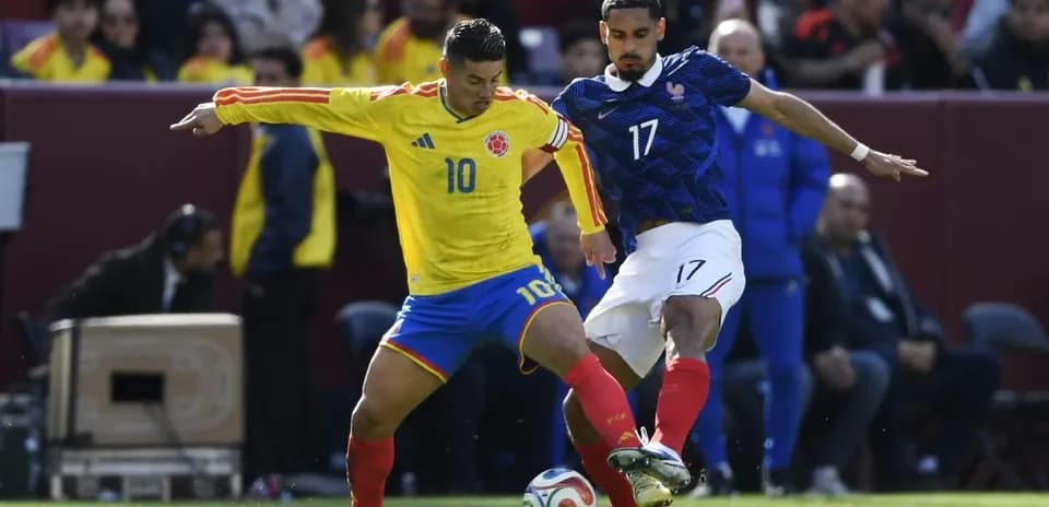Colombian player dribbling against French opponent