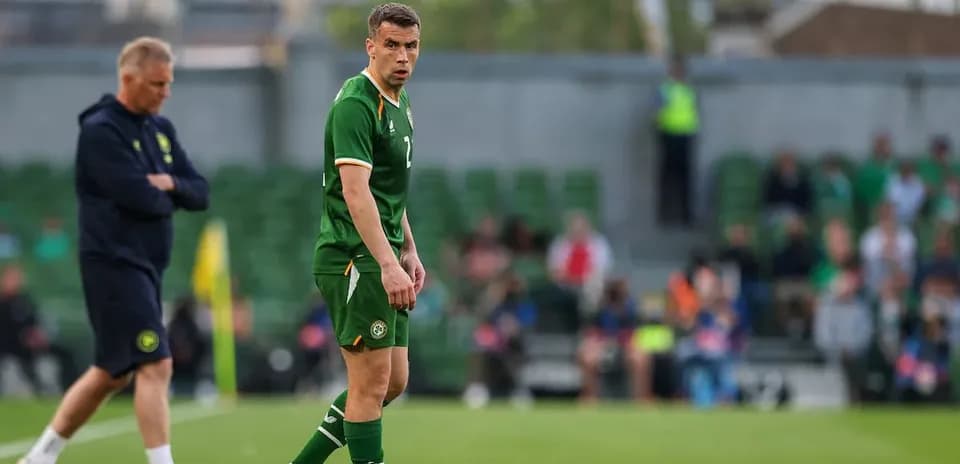 Irish player on field during match with coach nearby