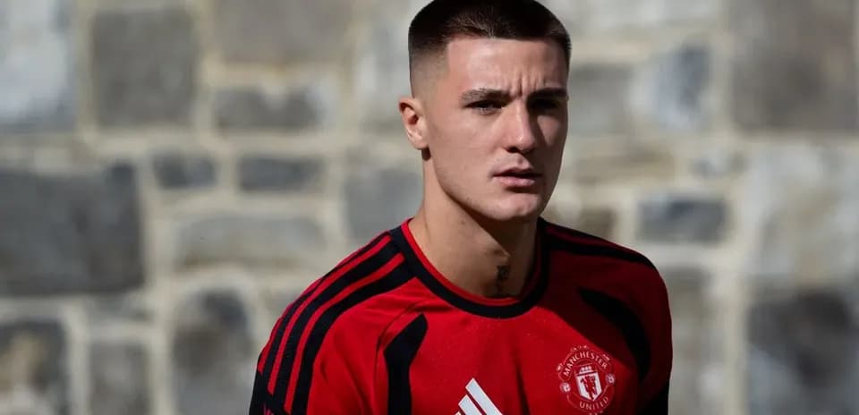 Player in Manchester United training kit posing outdoors