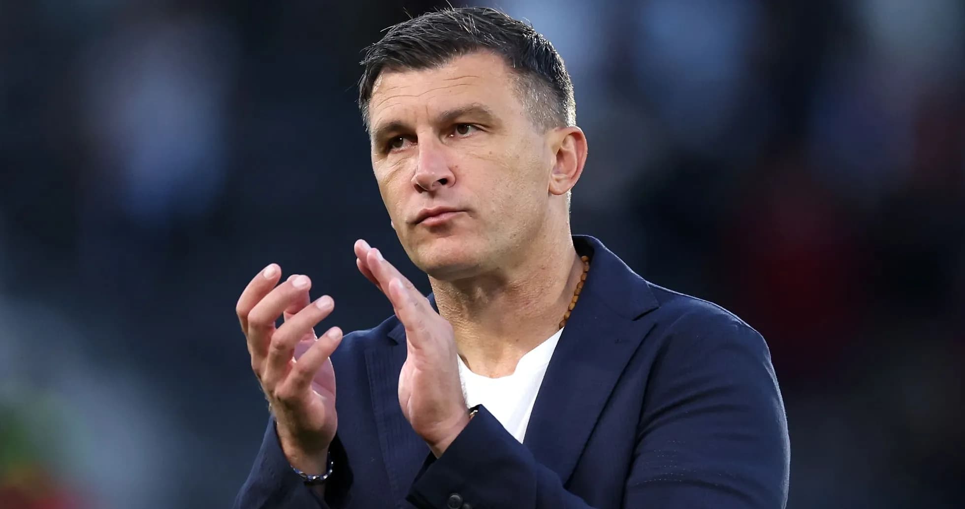 Coach applauding during a match on the sidelines