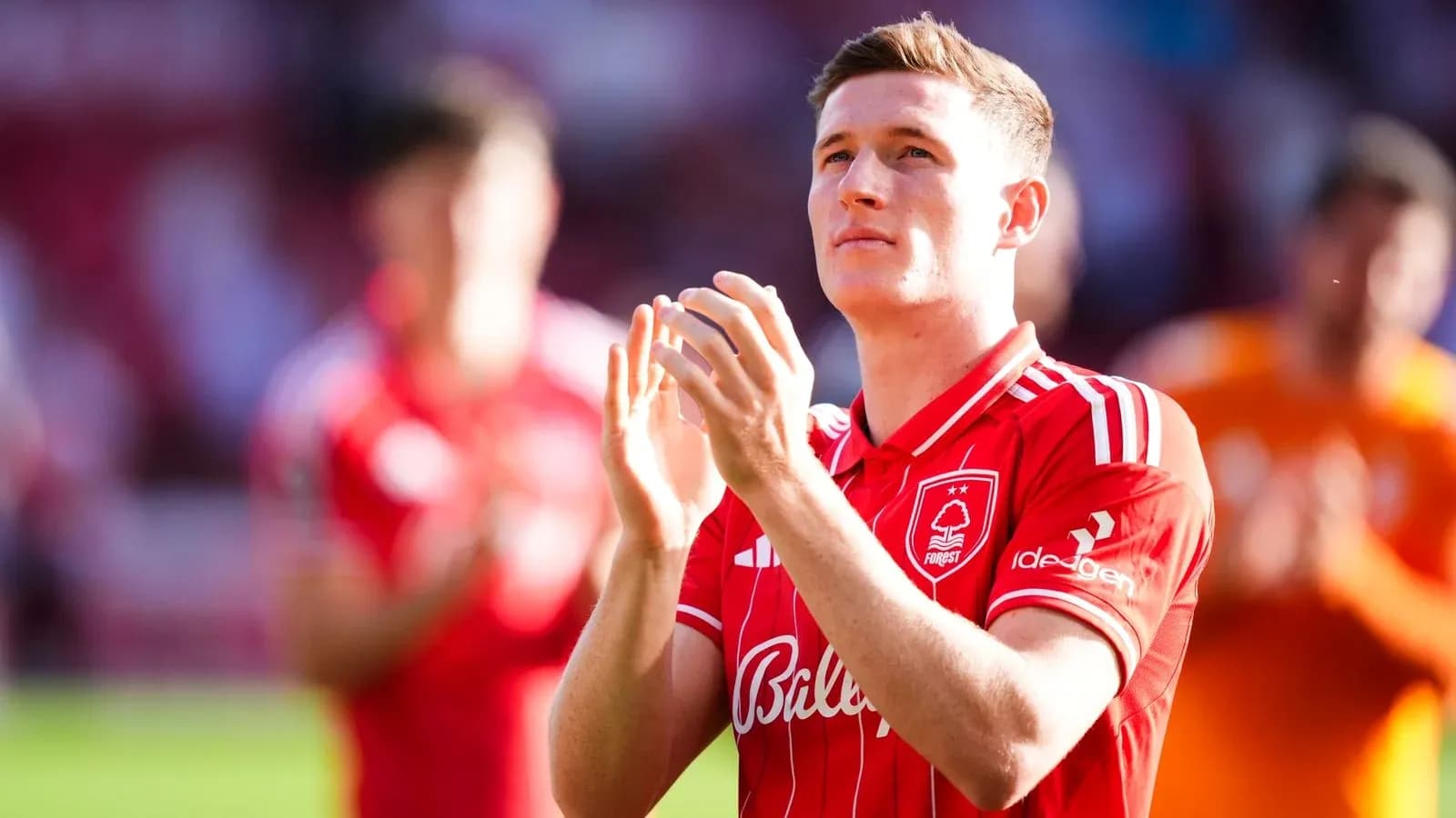 Player applauding fans wearing red team jersey