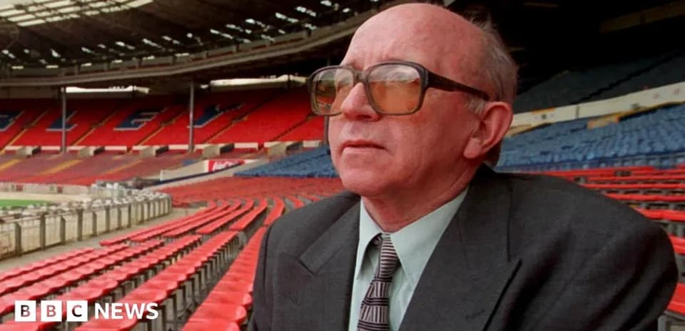 Person sitting in empty stadium stands, looking ahead