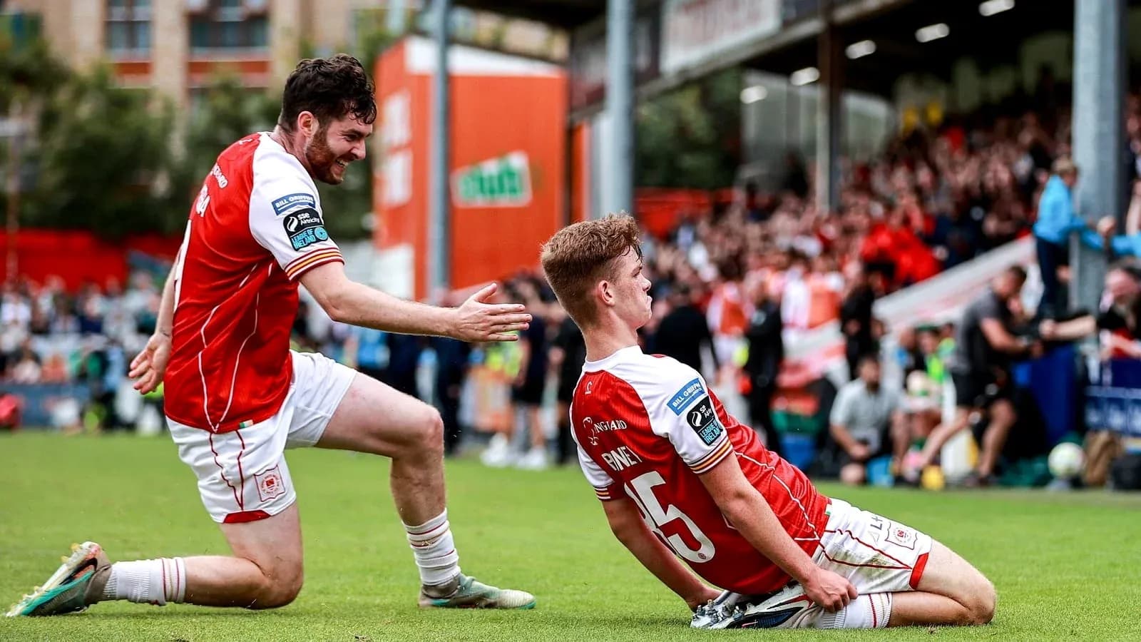 Two players celebrating a goal on the field