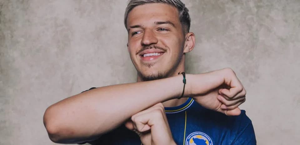 Player smiling and posing in national team jersey