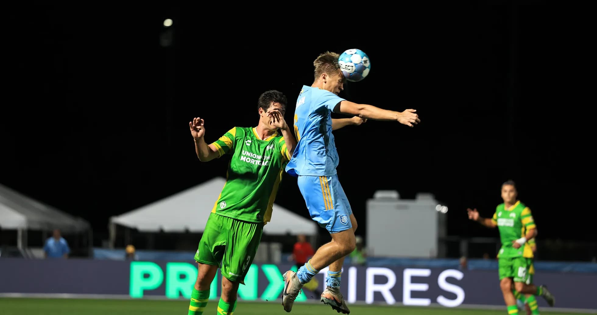 Players competing for the ball in USL match