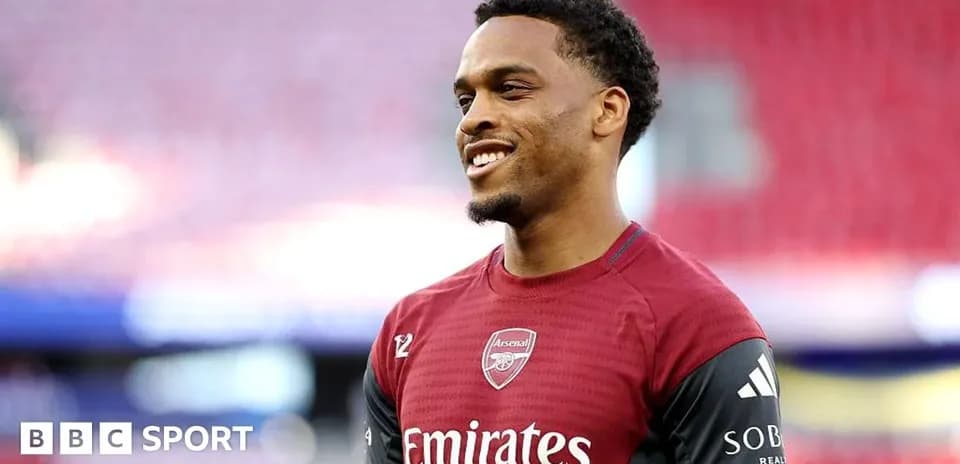 Player in Arsenal kit smiling during warm-up