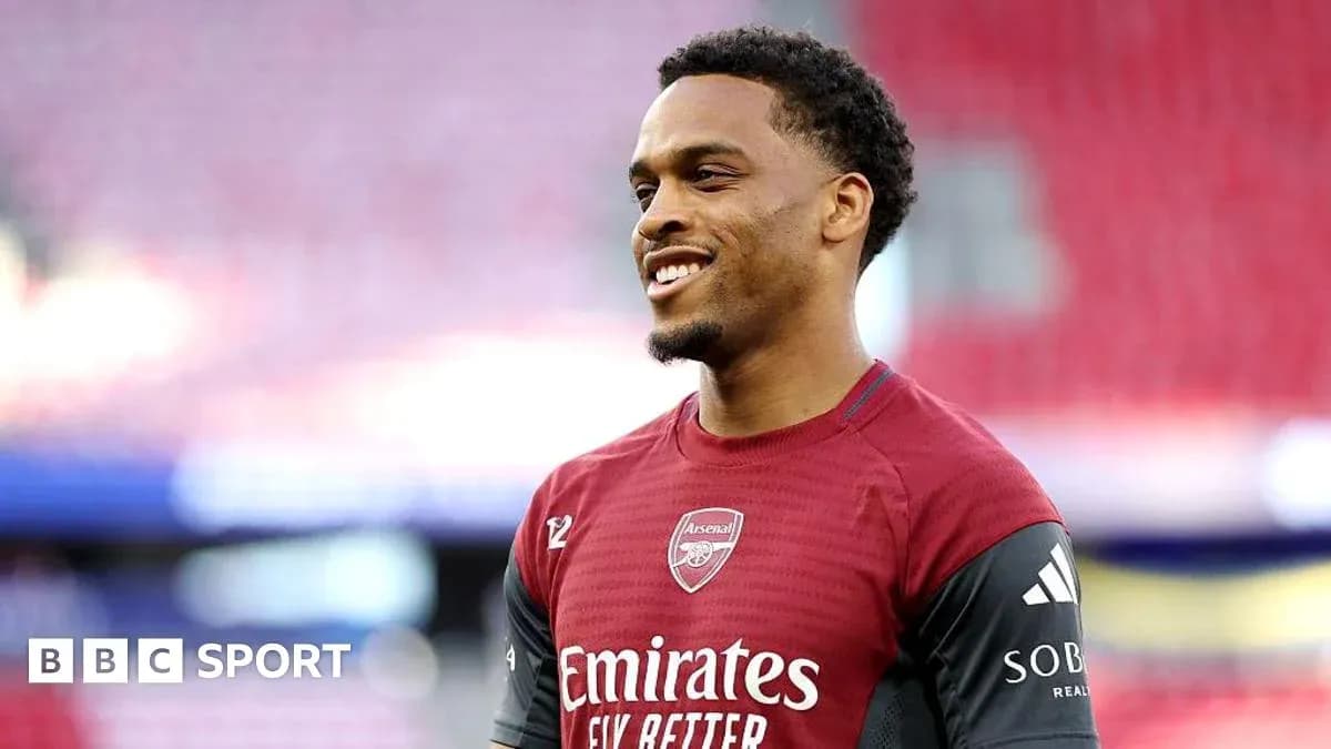 Player in Arsenal kit smiling during warm-up