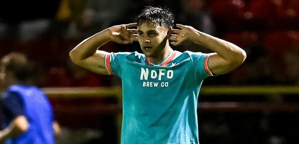 Player gesturing while wearing teal team jersey