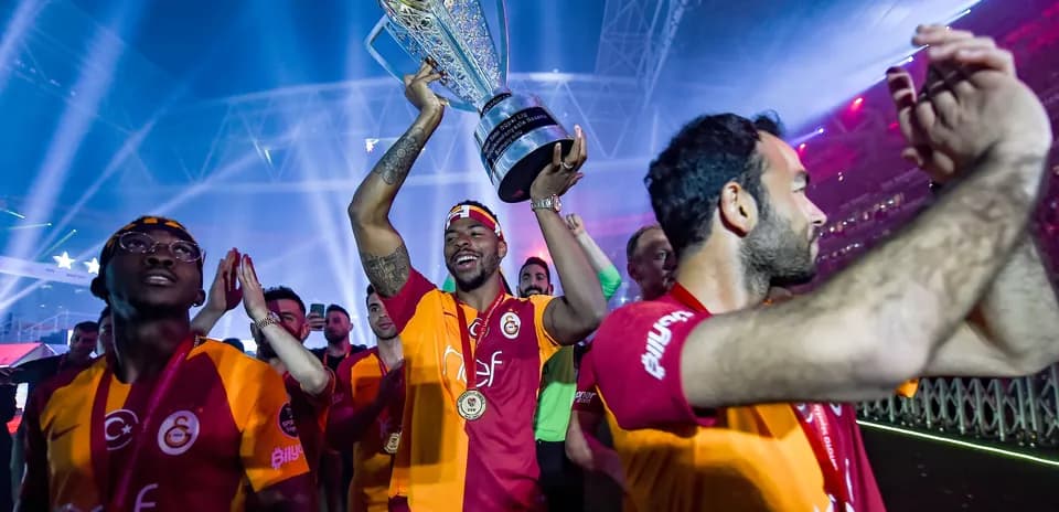 Player holding trophy with teammates celebrating