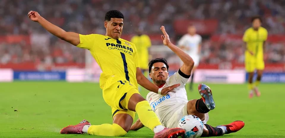 Villarreal player tackling Sevilla opponent during match