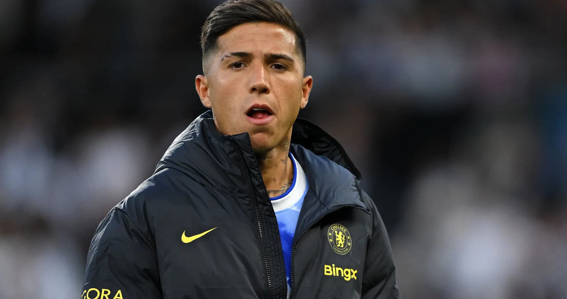 Player wearing Chelsea jacket on the sidelines