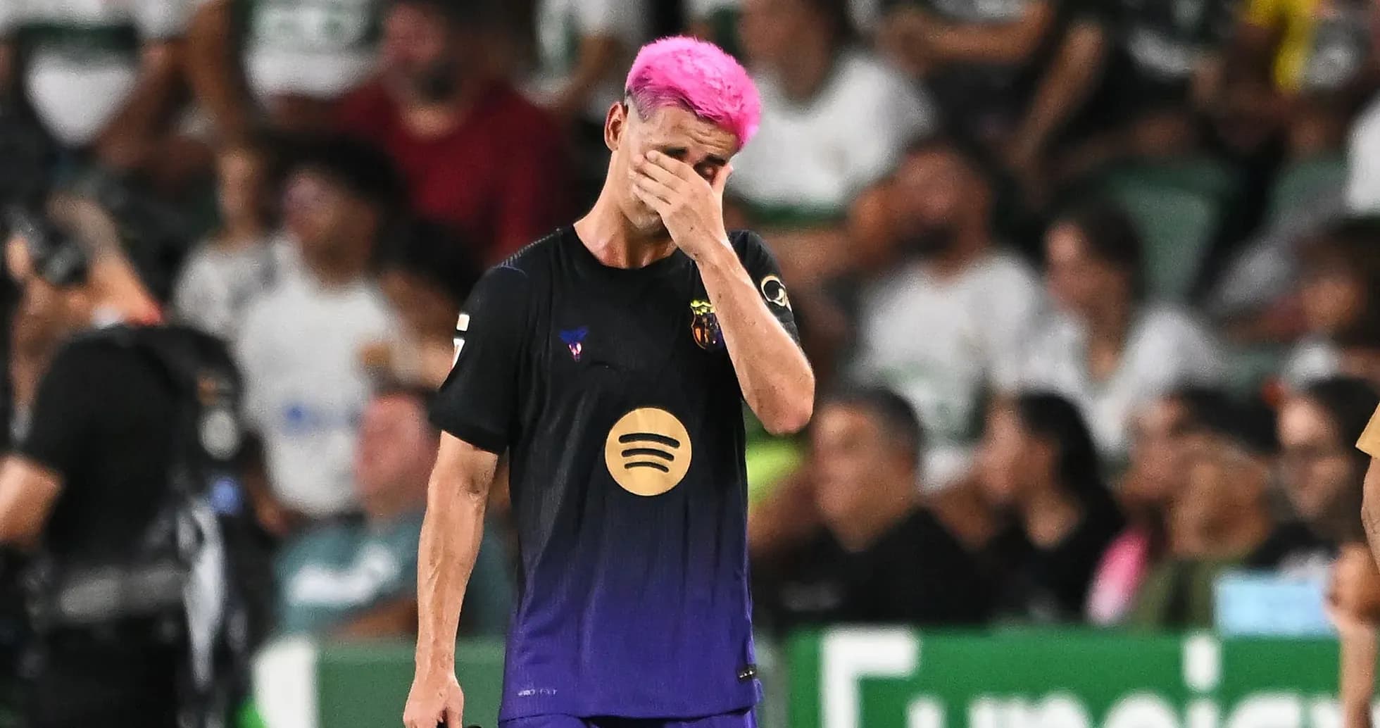 Player with pink hair walking off the pitch