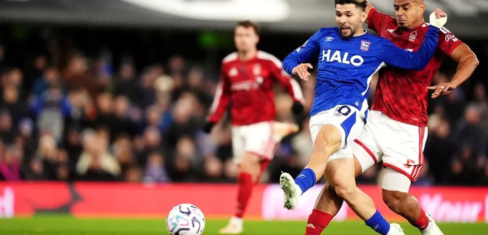 Player in blue tackling opponent in red during match