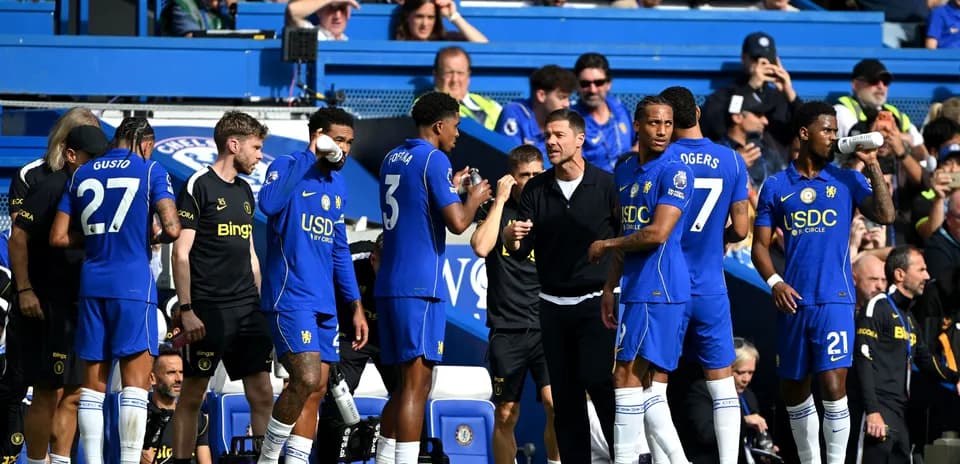Chelsea players discussing strategy on the sidelines