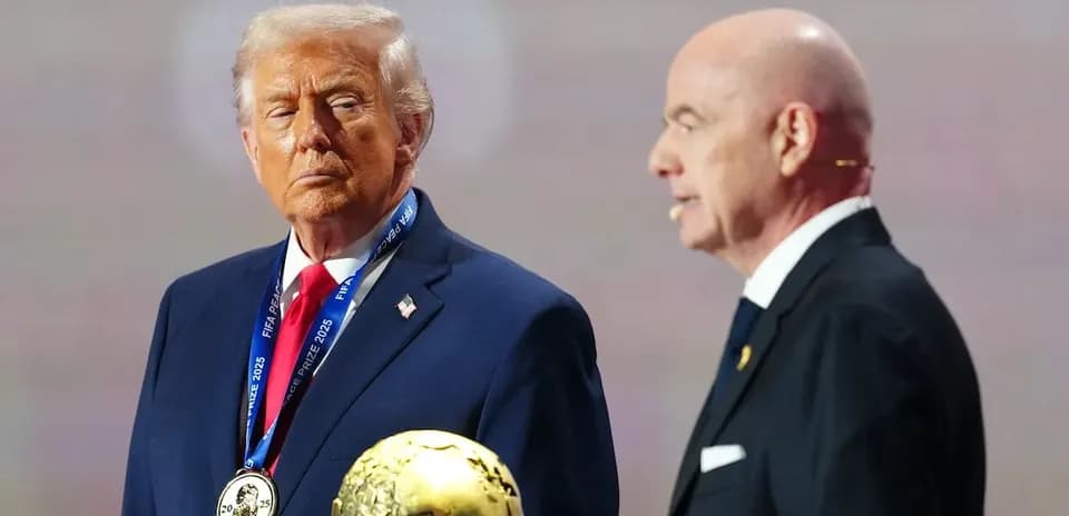 Two men at event holding FIFA prize trophy