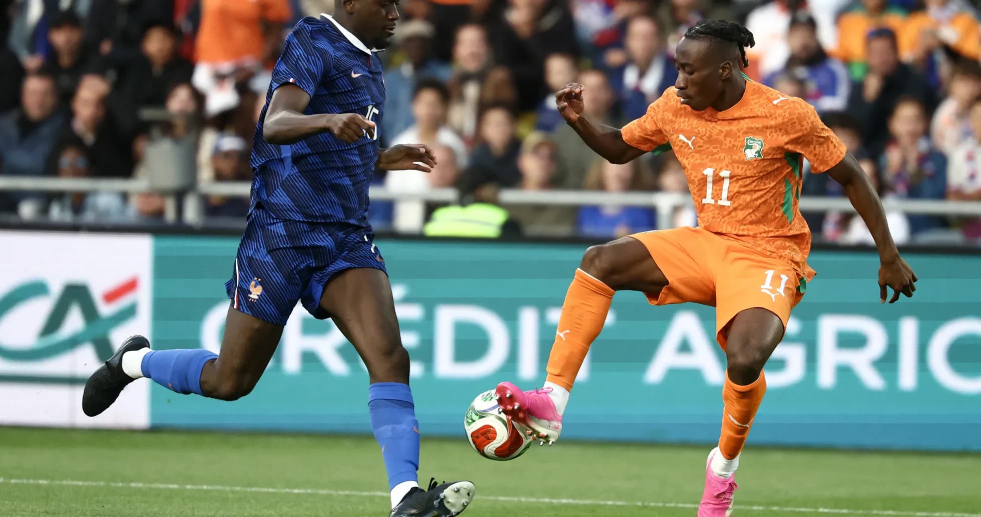 Player from France challenges Ivorian player for ball