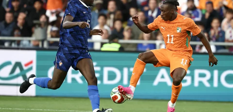 Player from France challenges Ivorian player for ball