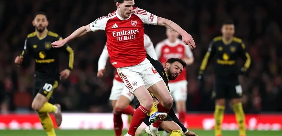Arsenal player challenged by opponent during match