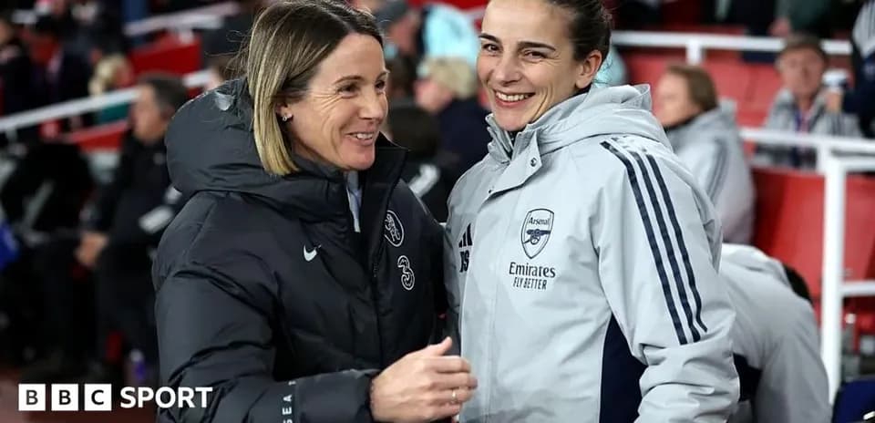 Two football coaches chatting on the sidelines